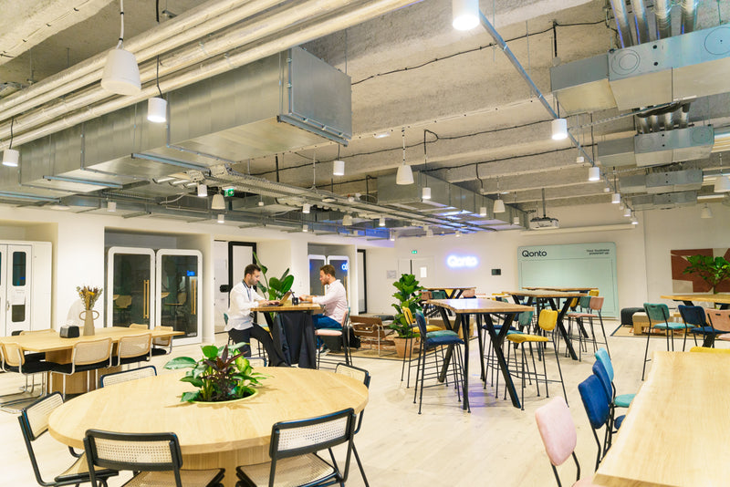 grande salle avec des tables et des chaises et dans le fond des cabines individuelles