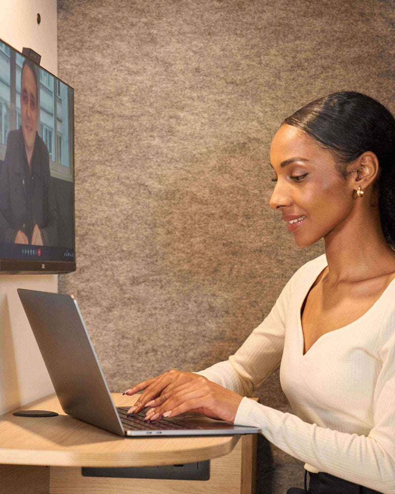 une femme assise qui tape sur son ordinateur