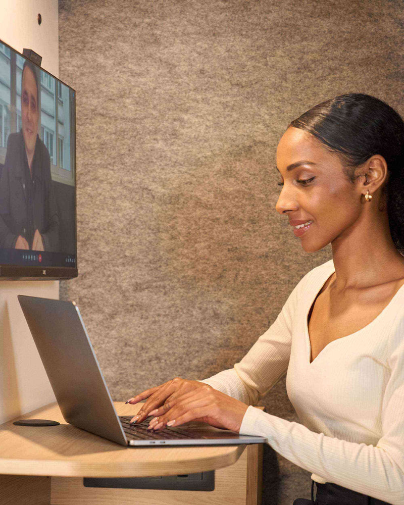 une femme assise qui tape sur son ordinateur 